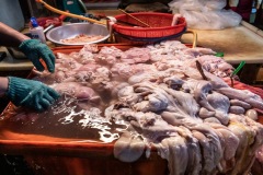 Vendor cleans and separates innards for sale at a wet market in Taipei. Taiwan, 2019.