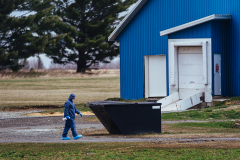 An inspector from the Canadian Food Inspection Agency (CFIA) walks towards a barn at a large duck farm wearing a full biohazard suit. A team of two was onsite at this facility in Racine, Quebec taking samples to test for the highly pathogenic avian influenza (H5N1). Canada, 2022. Victoria de Martigny / We Animals