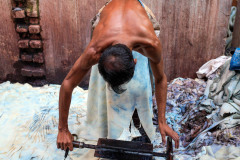In Hazaribagh, a part of western Dhaka reknowned for its tanneries,  a worker bends over a cow hide. Using a specially formed knive, he removes the chemically dissolved layer of fat from the skin.