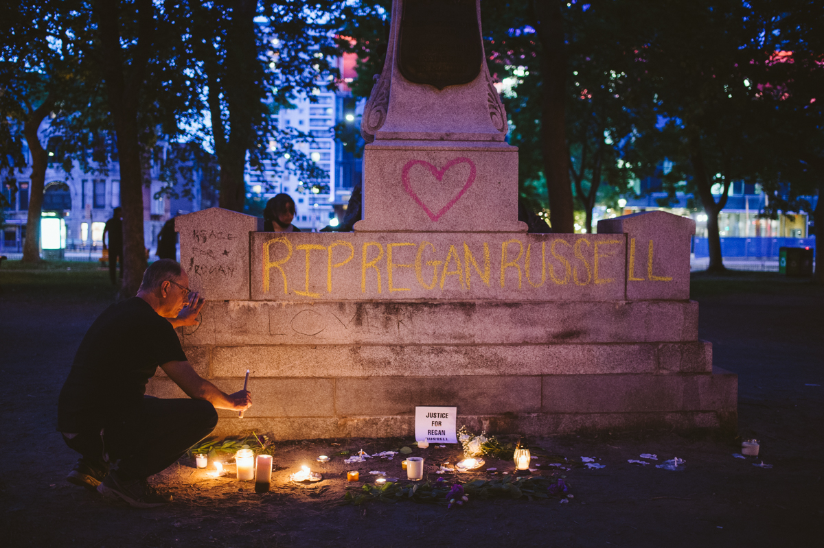 A man couches to pay his respects at the memorial created for fallen animal rights activist Regan Russell at Saint Louis Square in Montreal.